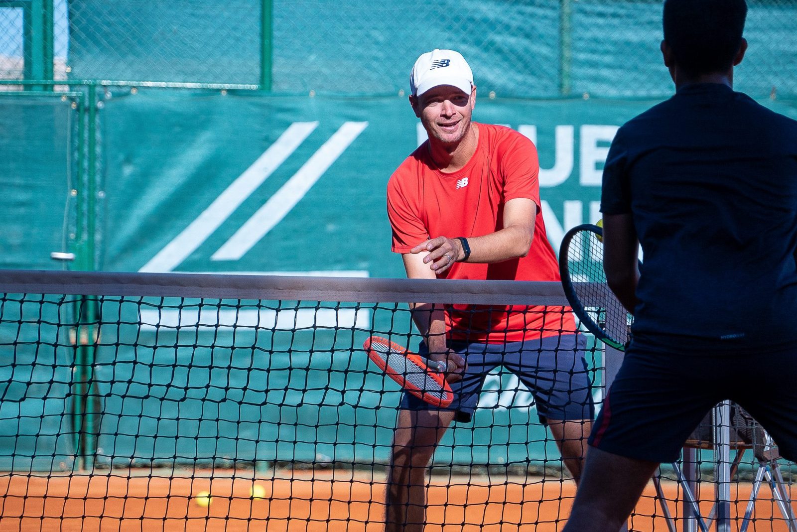 Two tennis players on the court playing tennis and having fun