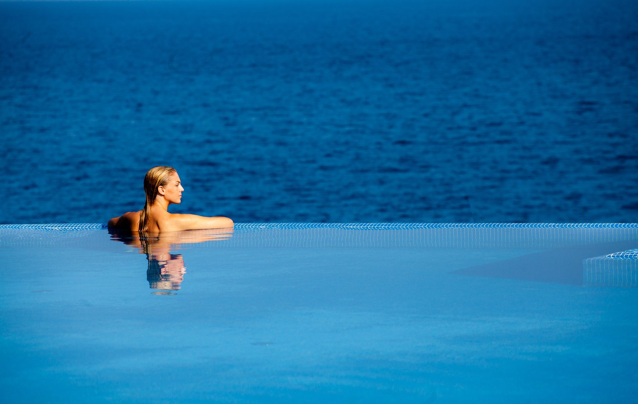 Girl swimming in the pool looking at the Adriatic sea
