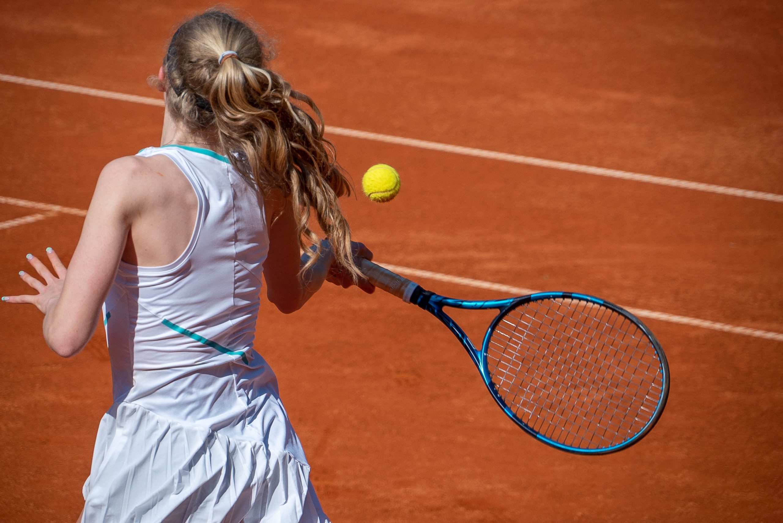 Girl playing tennis at the sunny tennis court at Ljubicic Tennis Acdemy